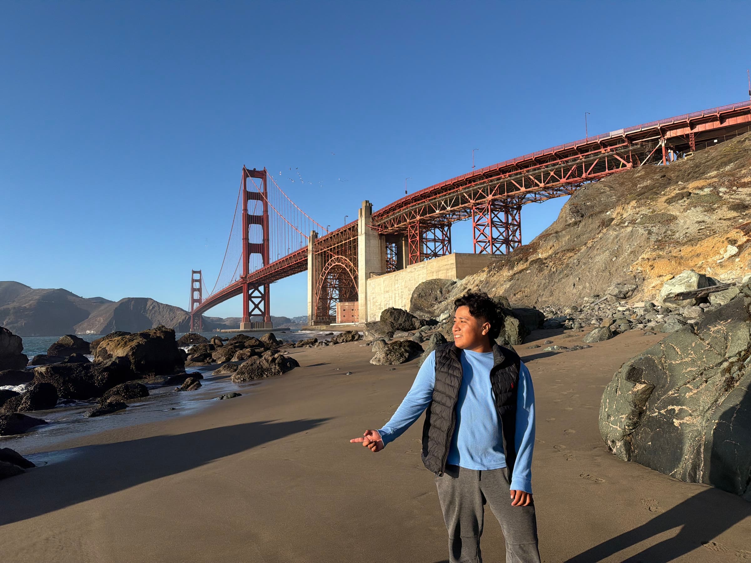 Ellis Alcantara on the San Francisco shoreline with the Golden Gate Bridge behind him